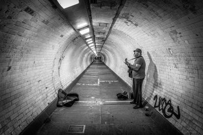 Straatfotografie muzikant in tunnel Londen in zwart-wit